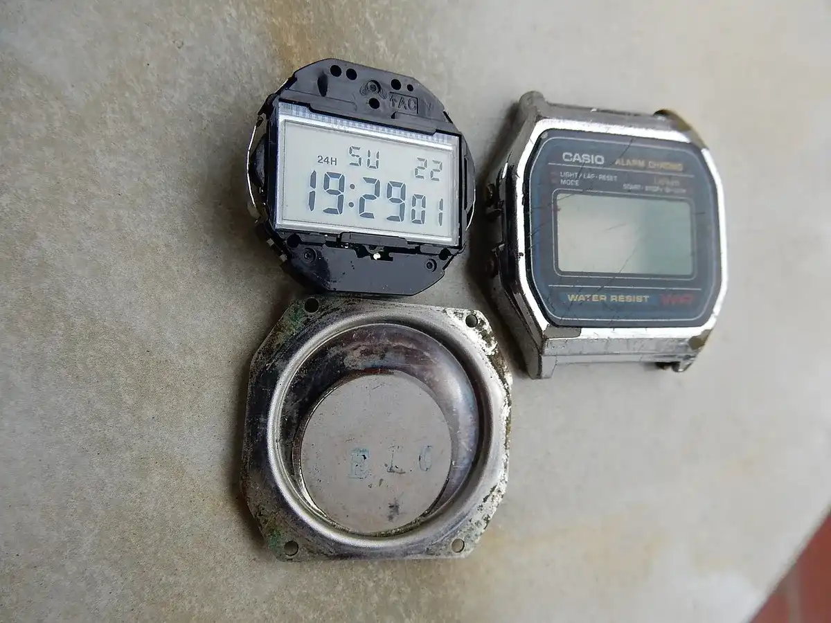 Casio A158W antiguo desmontado: el módulo digital fuera de la caja de acero, junto a la tapa trasera