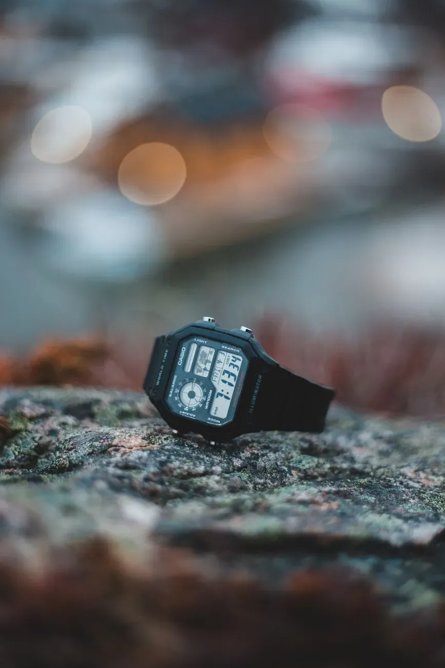 Casio AE-1200 negro con el mapa del mundo en la pantalla, sobre una superficie oscura