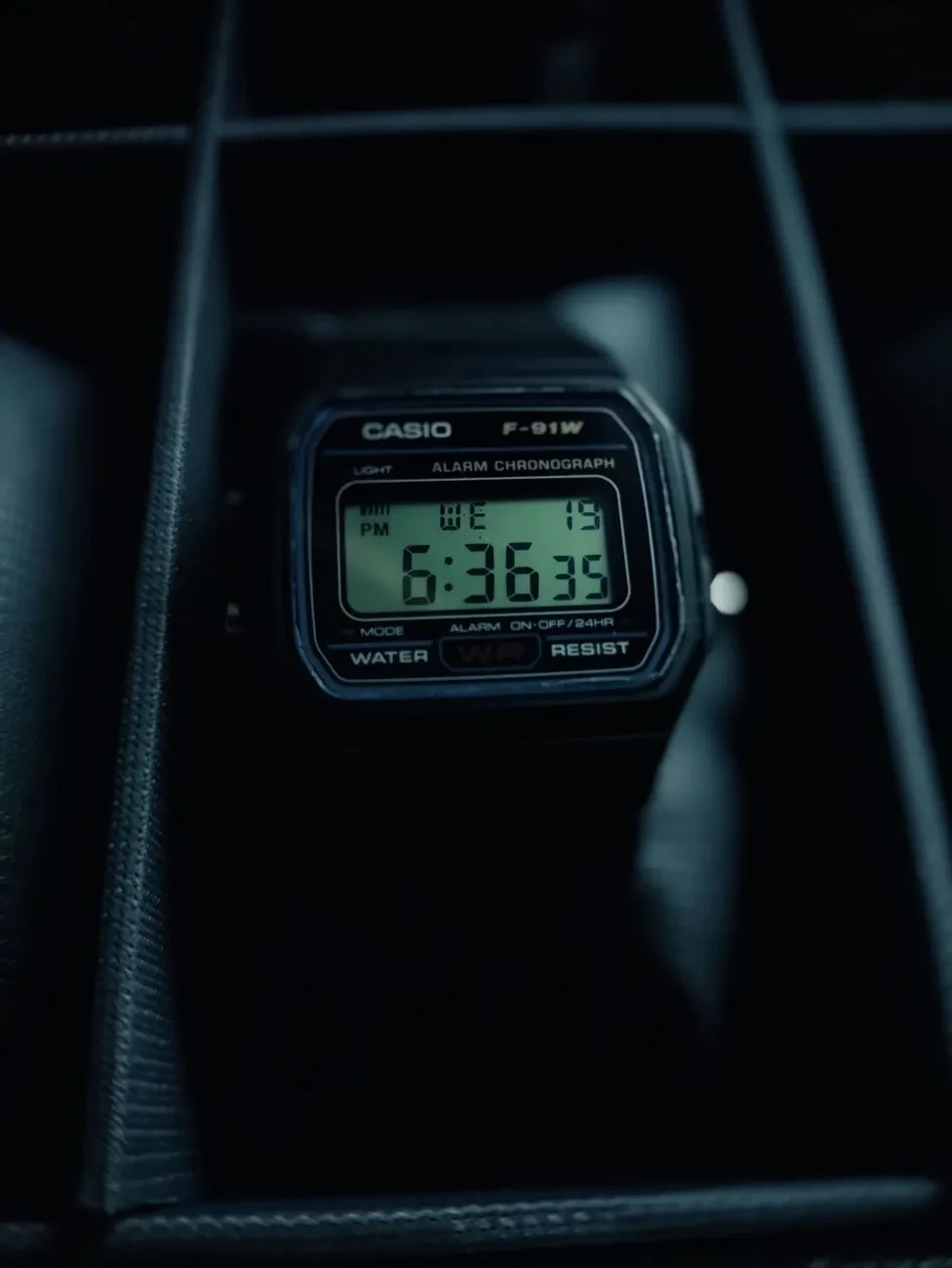 Casio F-91W negro de noche, con la pantalla digital iluminada