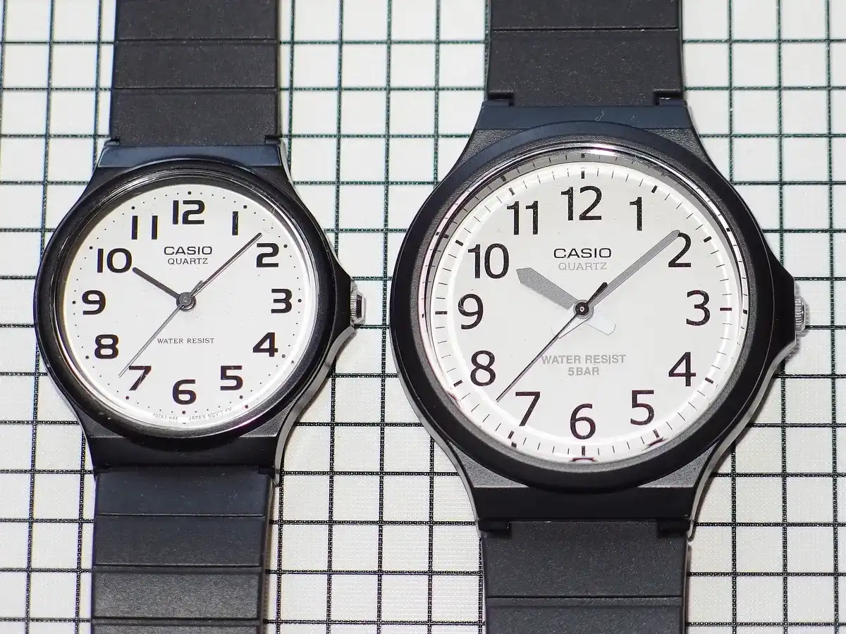 Dos Casio analógicos de esfera blanca sobre una cuadrícula: un MW-240 a la derecha y un MQ-24 a la izquierda, más pequeño
