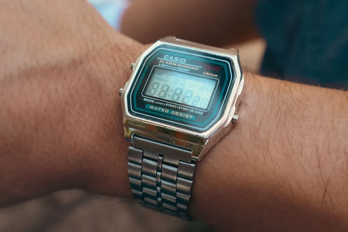 Reloj digital de estilo Casio Vintage con correa de acero en la muñeca, visto de cerca