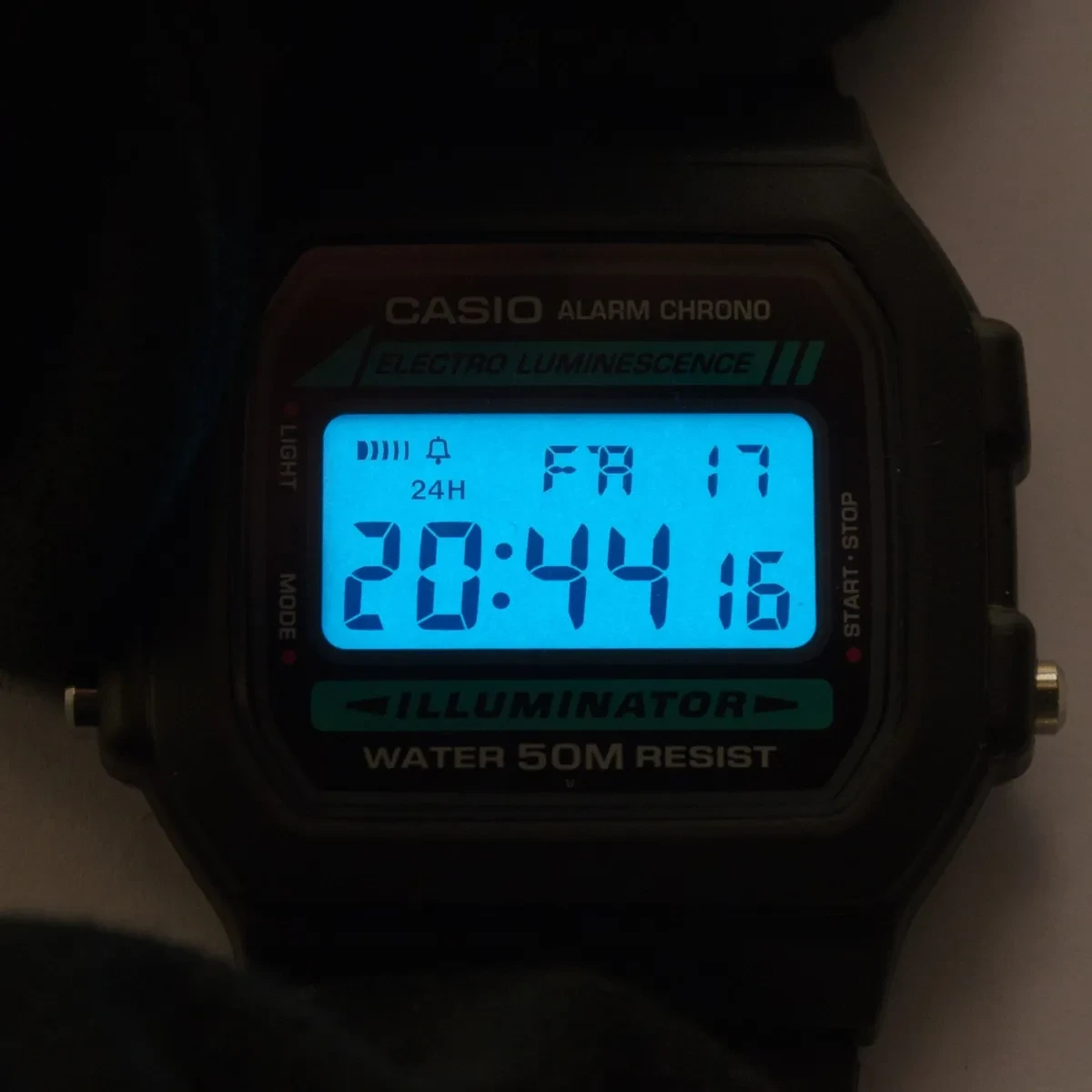 Pantalla de un Casio W-86 iluminada en azul a oscuras, con toda la superficie encendida por igual
