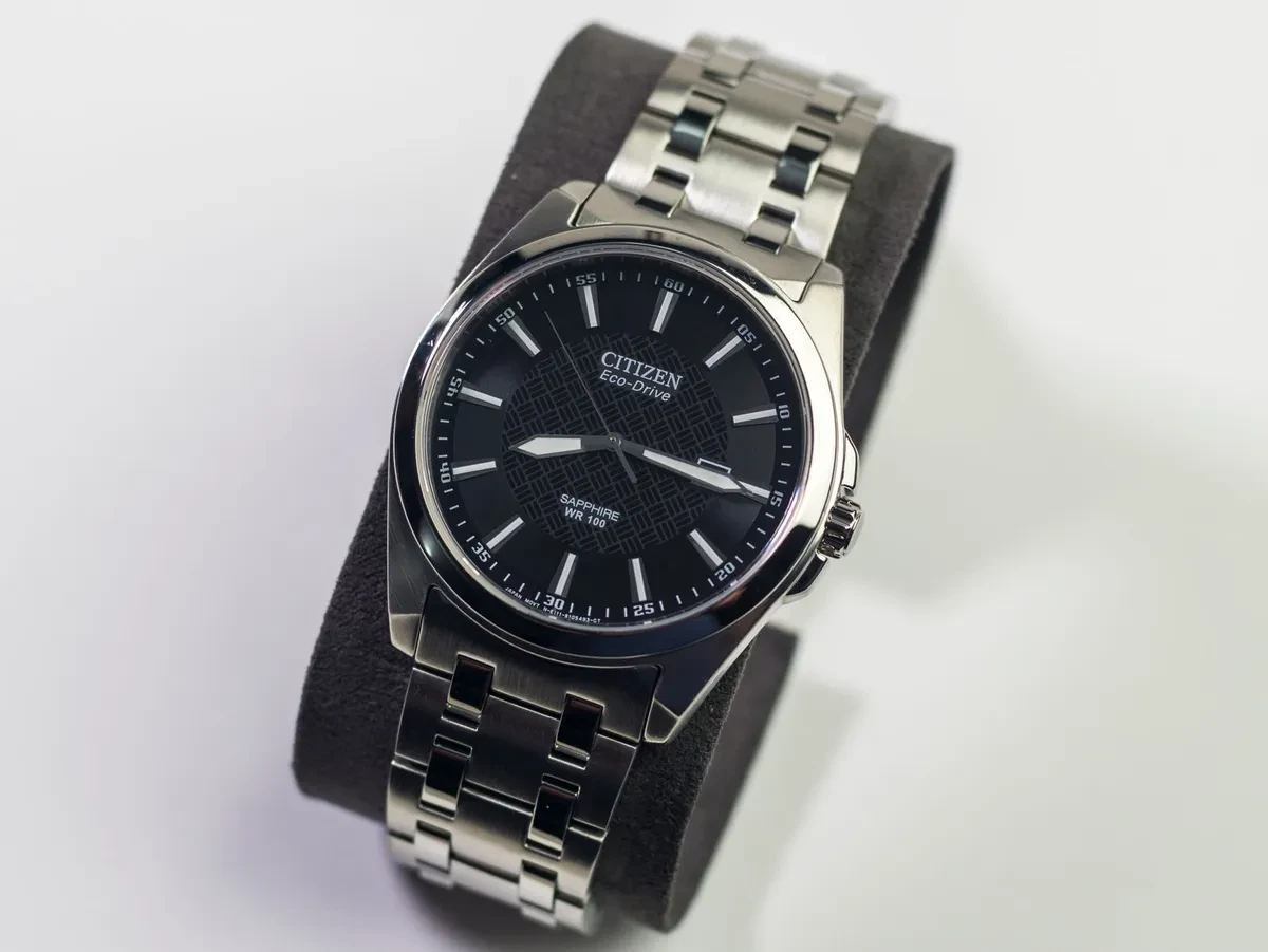 Reloj Citizen analógico de acero con esfera negra, apoyado sobre una superficie clara