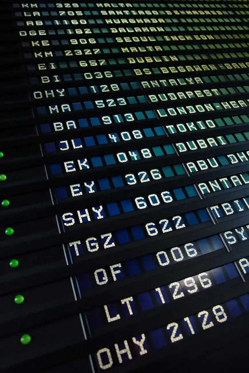Panel de salidas de un aeropuerto con números de vuelo y ciudades de destino en letras blancas